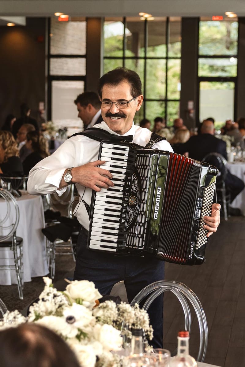 Lucio with accordion in scenic outdoor setting